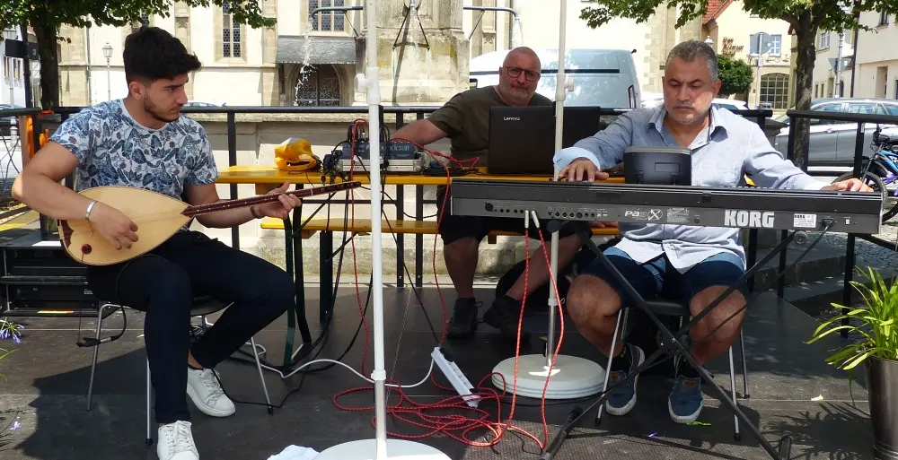 Musiker mit Saz, Laptop und Keyboard auf der Bühne am Marktplatz